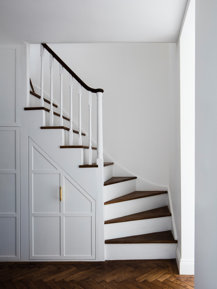 Modelo de escalera en U clásica de tamaño medio con escalones de madera, contrahuellas de madera pintada y barandilla de madera