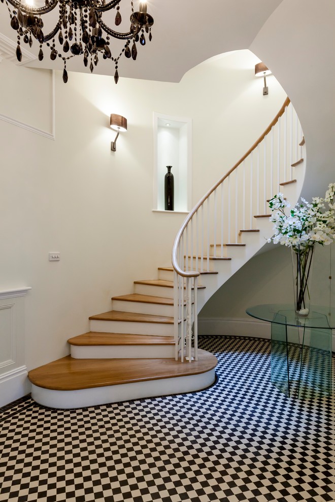 Свежая идея для дизайна: изогнутая лестница в современном стиле с деревянными ступенями - отличное фото интерьера