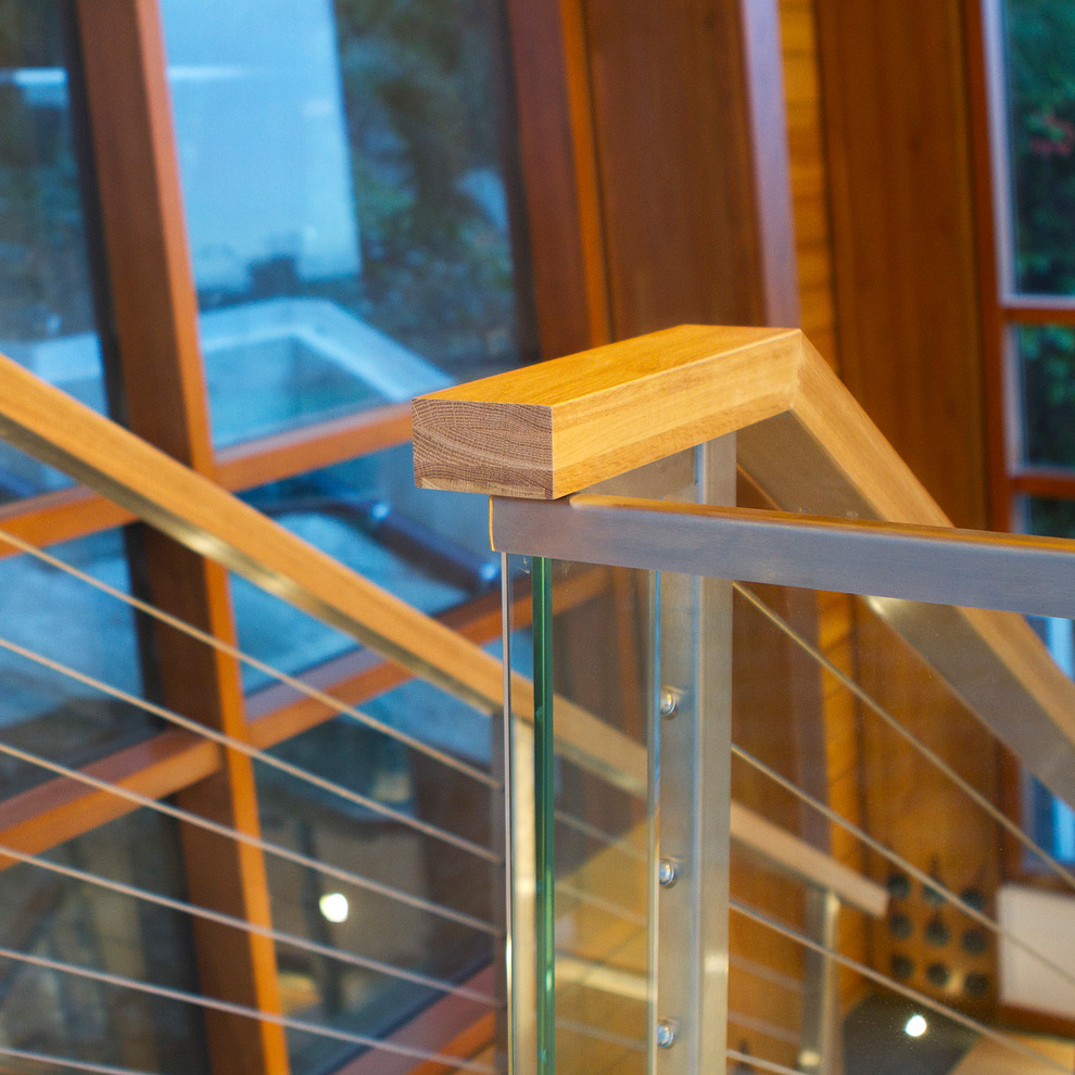 На фото: п-образная лестница среднего размера в стиле модернизм с деревянными ступенями и перилами из смешанных материалов без подступенок с