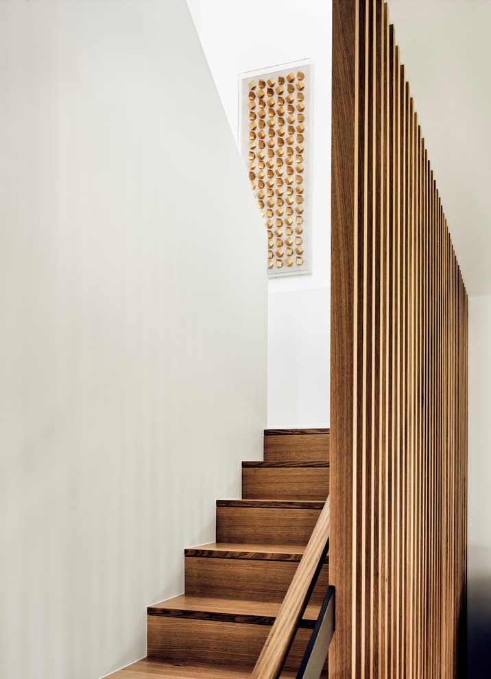 Diseño de escalera en U actual con escalones de madera, contrahuellas de madera y barandilla de madera