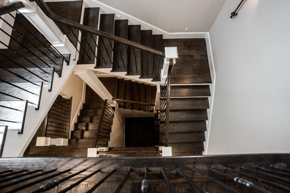 На фото: огромная п-образная лестница в стиле неоклассика (современная классика) с деревянными ступенями, крашенными деревянными подступенками и перилами из смешанных материалов