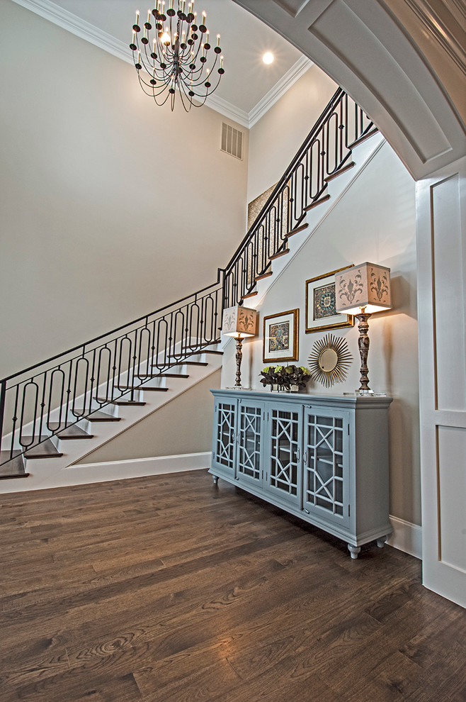 Large classic wood l-shaped staircase in Dallas with painted wood risers and feature lighting.