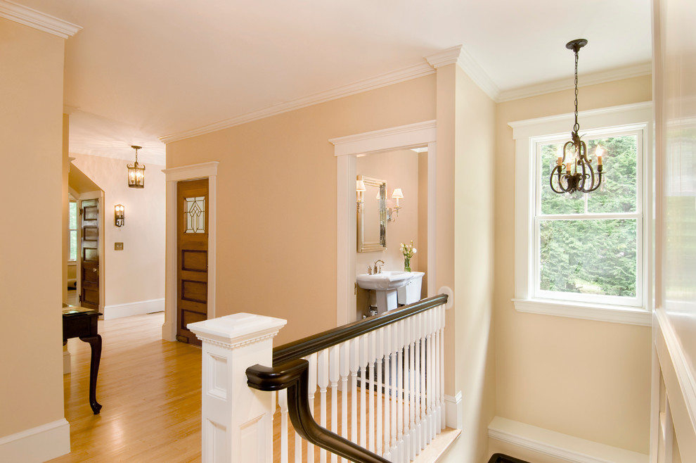Photo of a medium sized classic wood l-shaped wood railing staircase in Boston with painted wood risers.