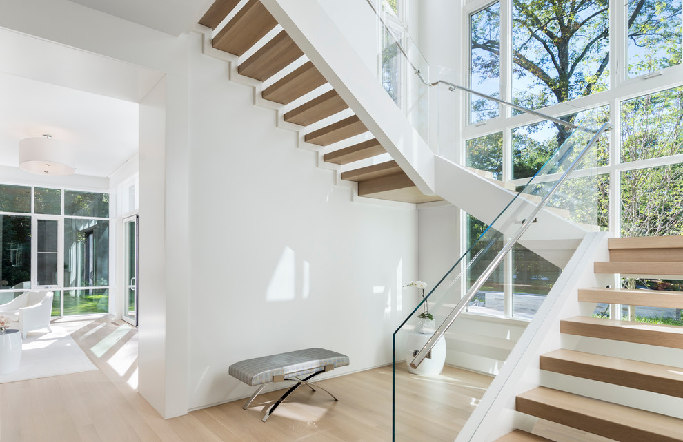 Large modern wood u-shaped staircase in Boston with open risers and feature lighting.