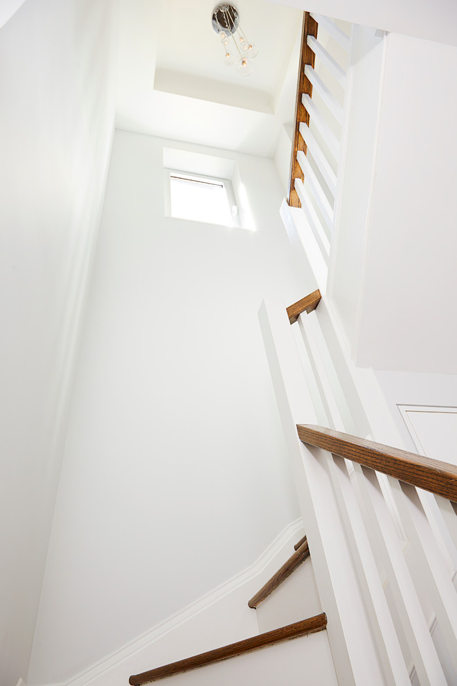 Ejemplo de escalera en U clásica renovada pequeña con escalones de madera y contrahuellas de madera pintada