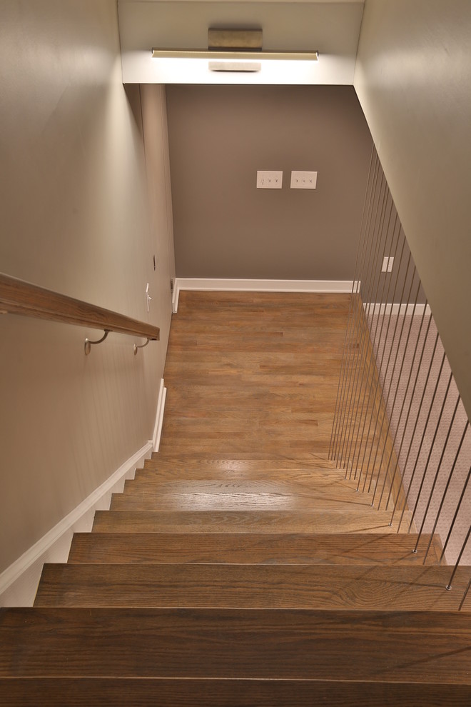 Idée de décoration pour un escalier droit design de taille moyenne avec des marches en bois et des contremarches en bois.