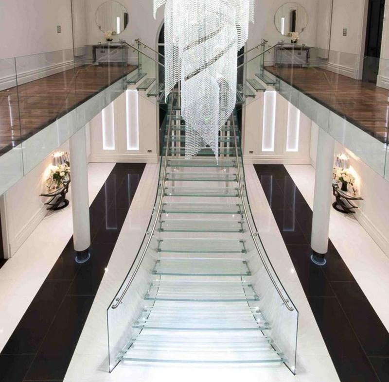 Пример оригинального дизайна: огромная лестница на больцах в современном стиле с стеклянными ступенями, стеклянными подступенками и стеклянными перилами