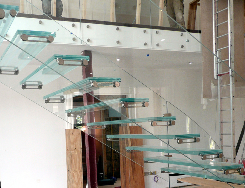 Imagen de escalera suspendida actual extra grande con escalones de vidrio, contrahuellas de vidrio y barandilla de vidrio