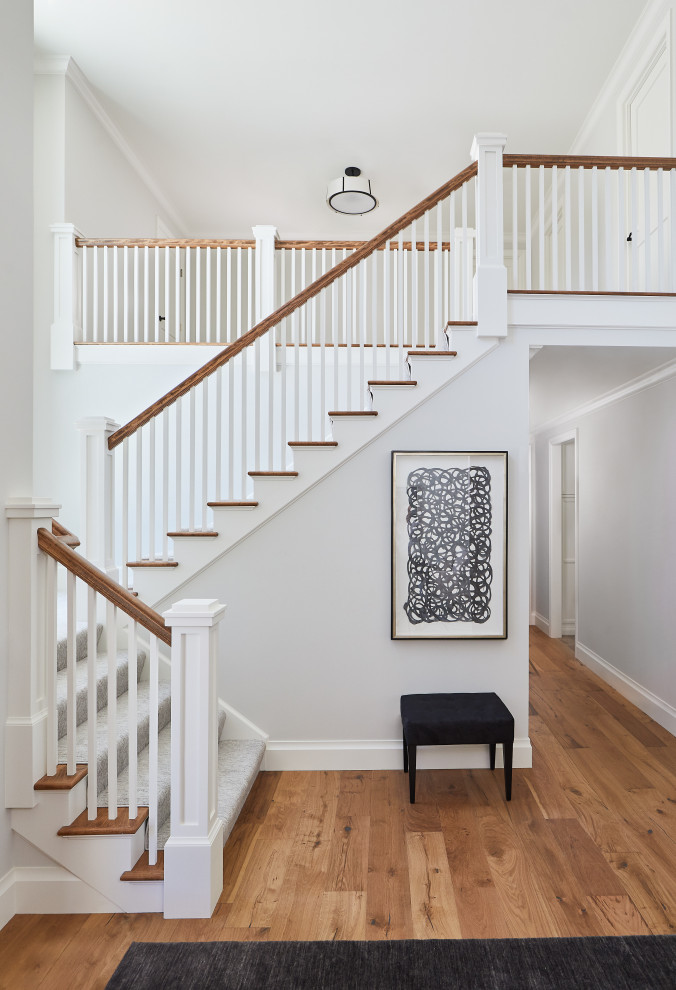 Foto de escalera en L de estilo de casa de campo grande con escalones enmoquetados, contrahuellas enmoquetadas y barandilla de madera