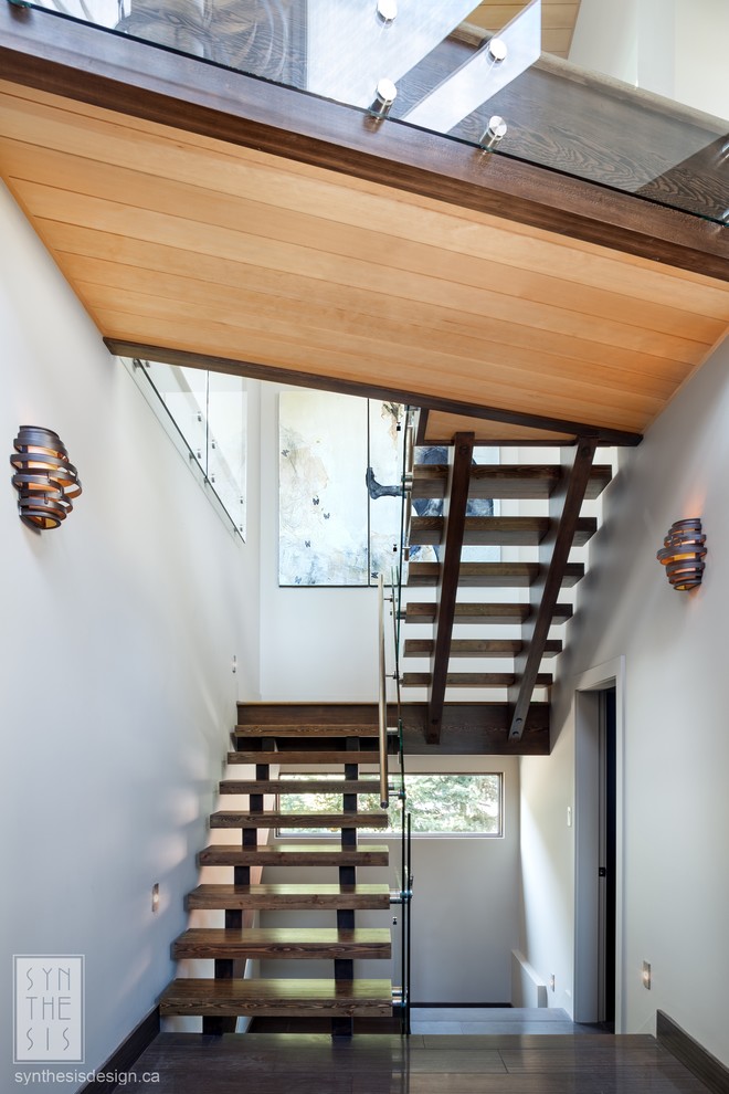 Diseño de escalera en U contemporánea grande sin contrahuella con escalones de madera y barandilla de vidrio