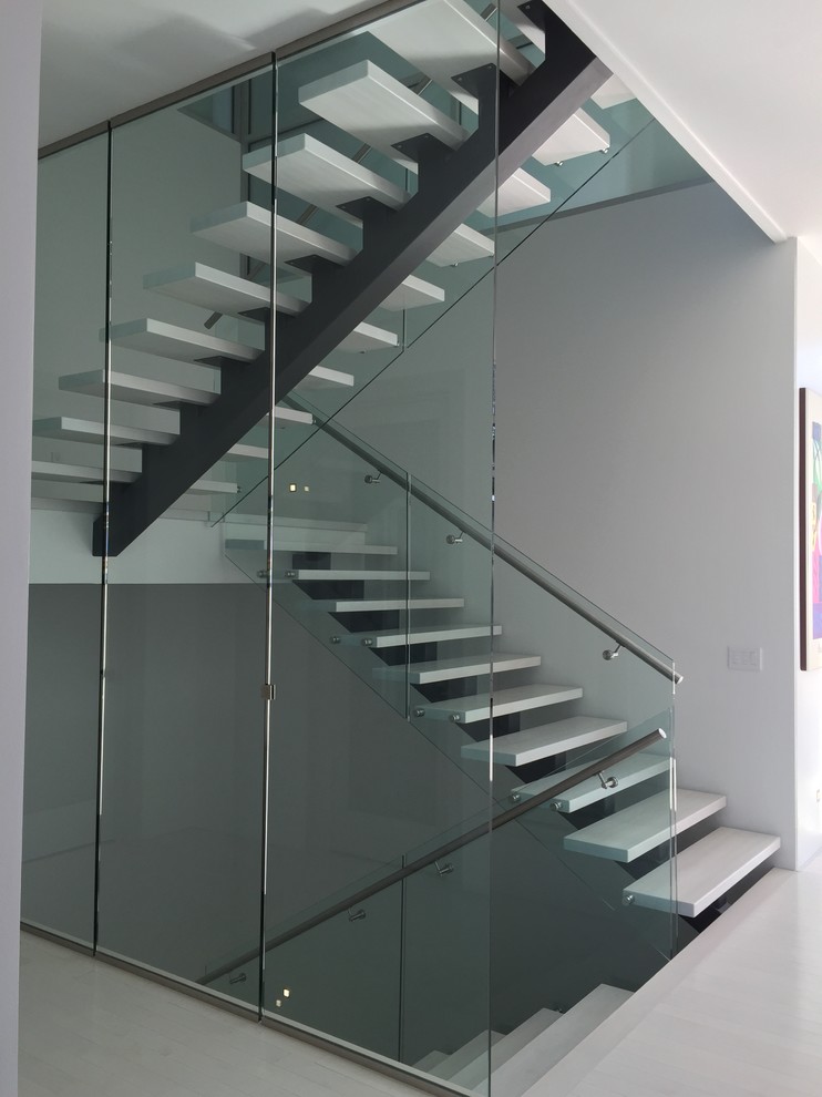This is an example of a medium sized modern u-shaped staircase in Calgary with limestone treads and open risers.