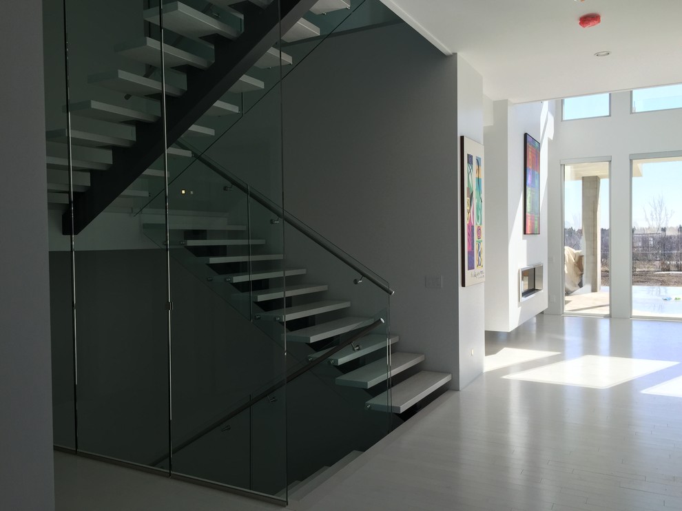 Mittelgroße Moderne Treppe in U-Form mit Kalk-Treppenstufen und offenen Setzstufen in Calgary