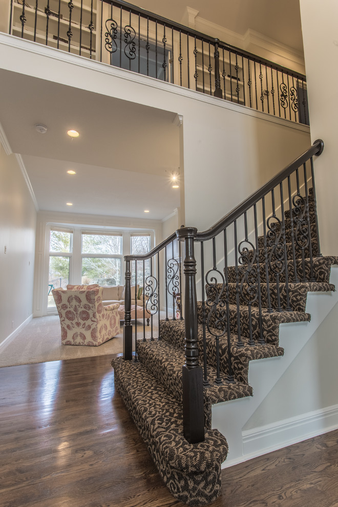 На фото: прямая лестница среднего размера в классическом стиле с ступенями с ковровым покрытием, ковровыми подступенками и перилами из смешанных материалов с