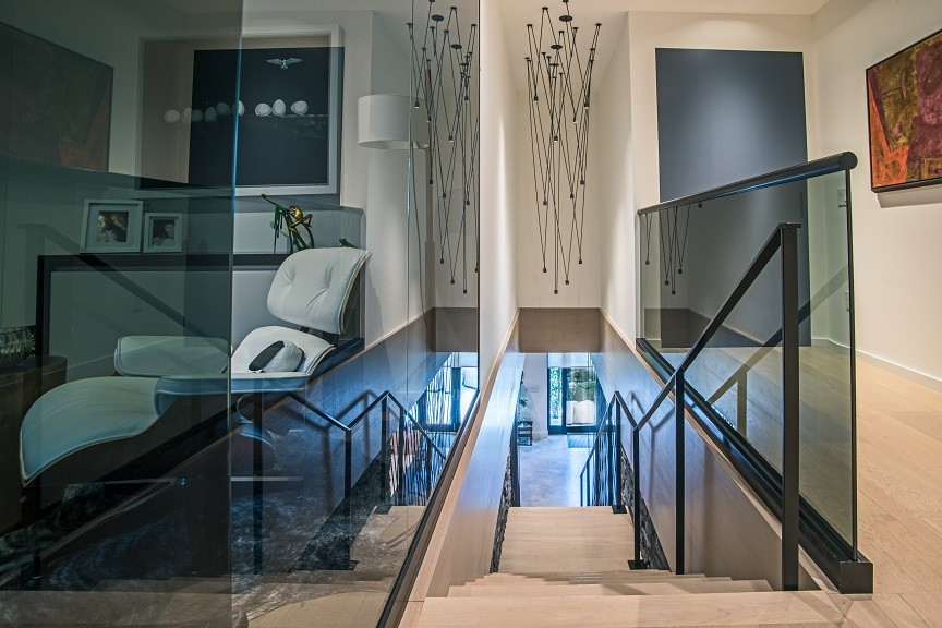 Aménagement d'un escalier droit moderne de taille moyenne avec des marches en bois, des contremarches en bois, un garde-corps en métal et éclairage.