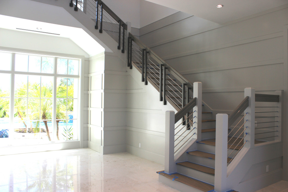Diseño de escalera en L clásica renovada grande con escalones de madera, contrahuellas de madera, barandilla de varios materiales y madera