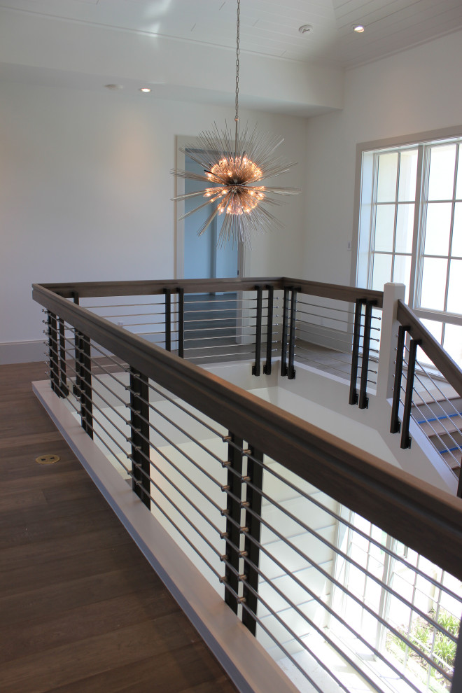Ejemplo de escalera en L clásica renovada grande con escalones de madera, contrahuellas de madera, barandilla de varios materiales y madera