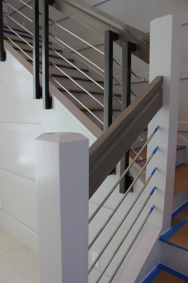 Ejemplo de escalera en L tradicional renovada grande con escalones de madera, contrahuellas de madera, barandilla de varios materiales y madera
