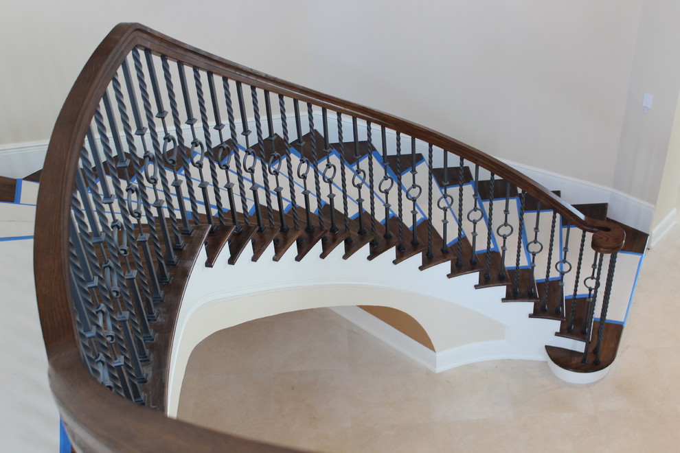 Diseño de escalera curva mediterránea grande con escalones de madera, contrahuellas con baldosas y/o azulejos y barandilla de varios materiales