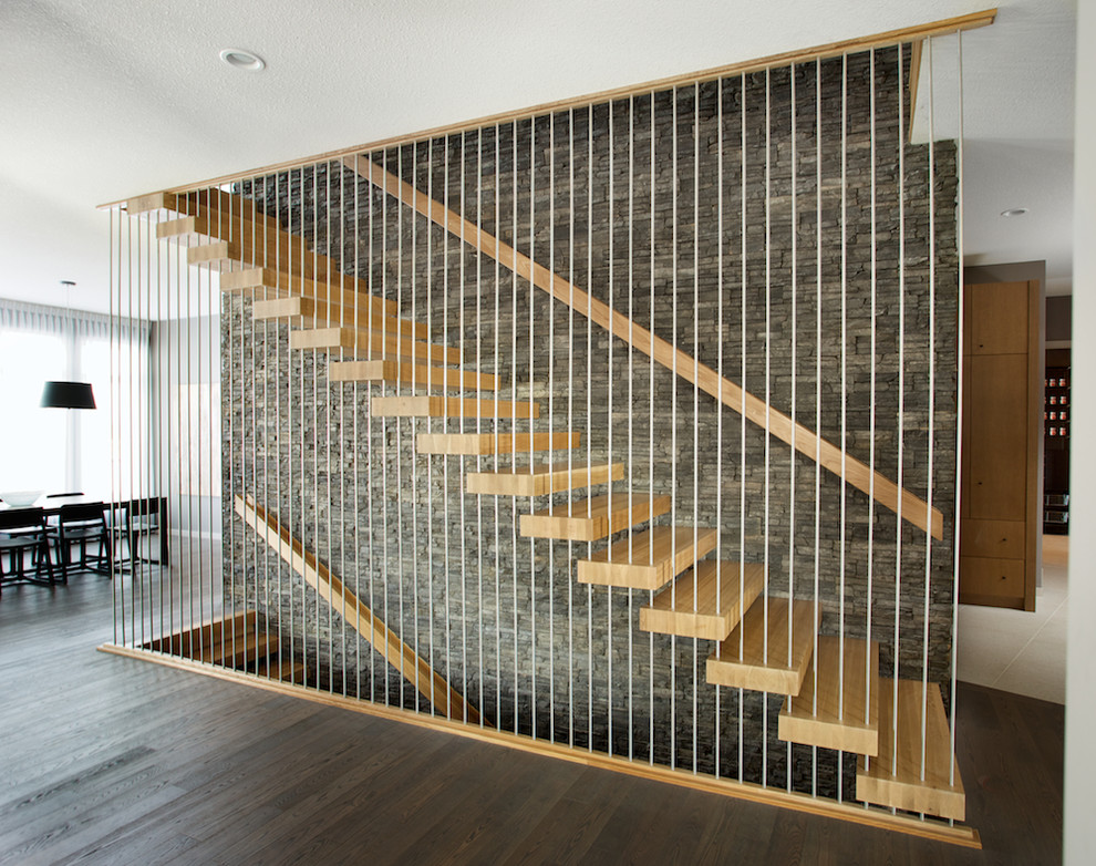 Foto de escalera suspendida minimalista sin contrahuella con escalones de madera y barandilla de varios materiales