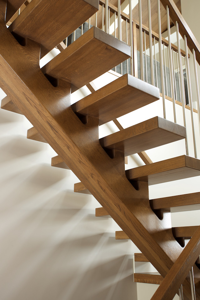 На фото: лестница на больцах в современном стиле с деревянными ступенями и перилами из смешанных материалов без подступенок