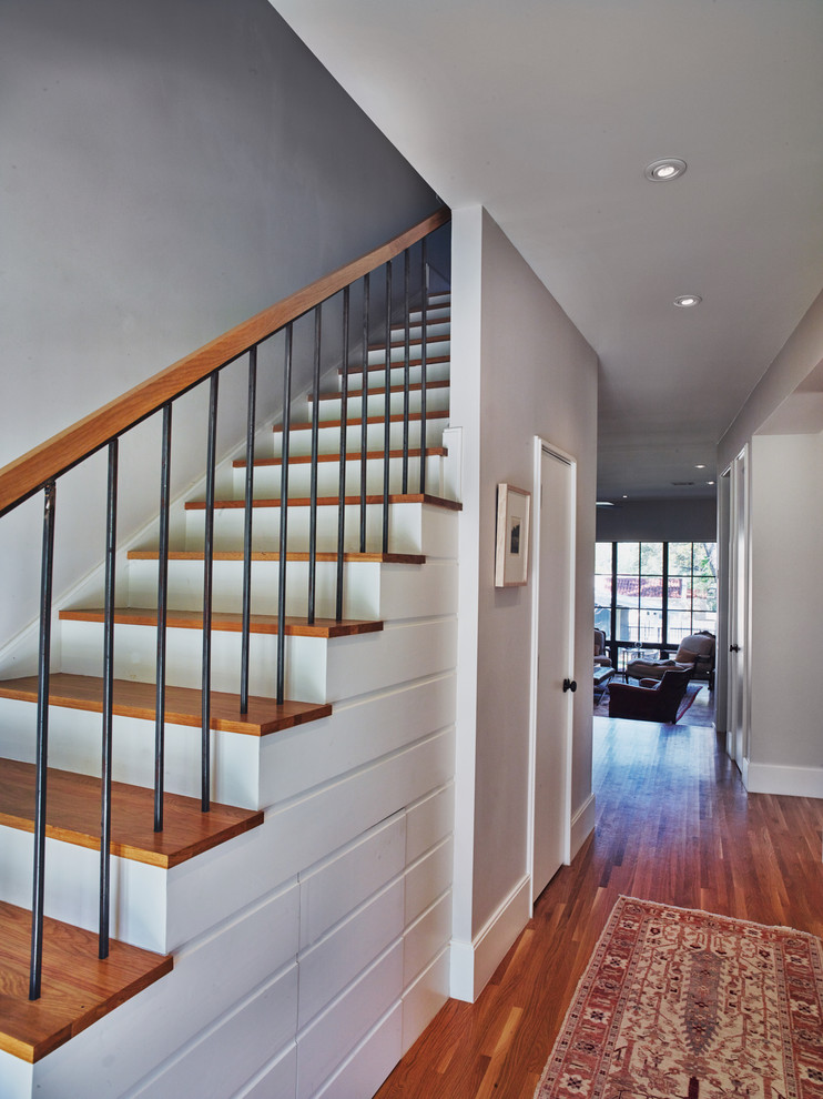 Diseño de escalera recta minimalista con escalones de madera y contrahuellas de madera pintada