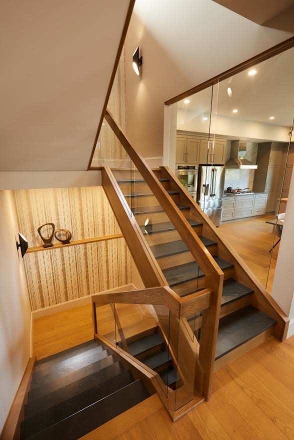 На фото: п-образная деревянная лестница в стиле модернизм с ступенями из сланца и перилами из смешанных материалов