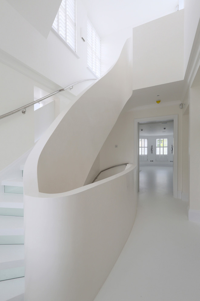 Staircase - small contemporary curved staircase idea in London with glass risers