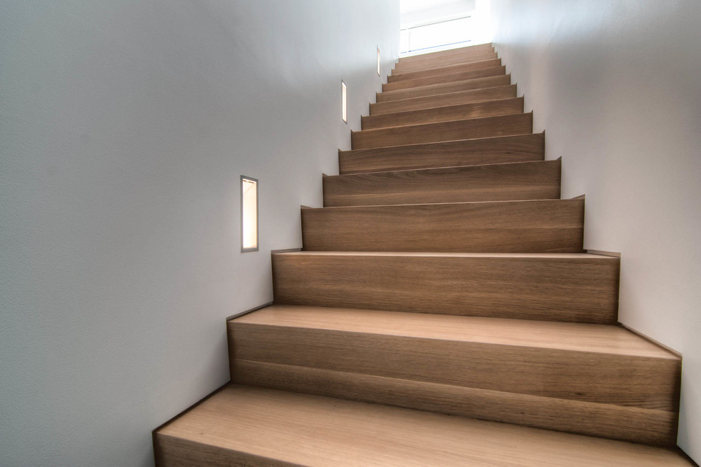 Imagen de escalera recta moderna de tamaño medio con escalones de madera y contrahuellas de madera