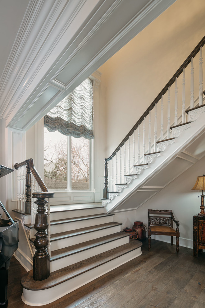 Стильный дизайн: огромная угловая деревянная лестница в классическом стиле с деревянными перилами - последний тренд
