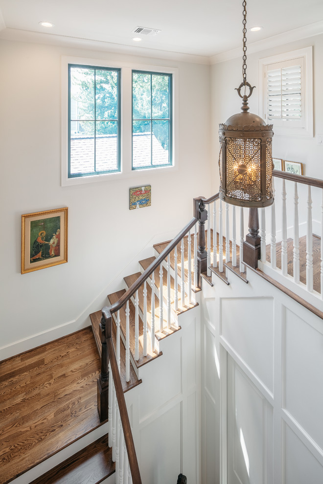 Foto de escalera en U clásica renovada extra grande con escalones de madera, barandilla de madera y contrahuellas de madera