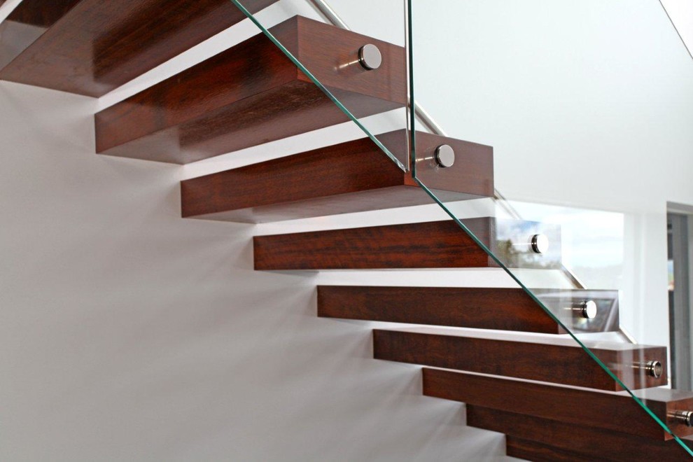 This is an example of an expansive modern wood floating staircase in Hamilton with open risers.