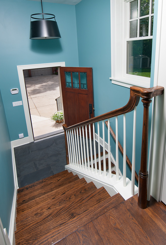 Ejemplo de escalera en U de estilo americano de tamaño medio con escalones de madera, contrahuellas de madera y barandilla de madera