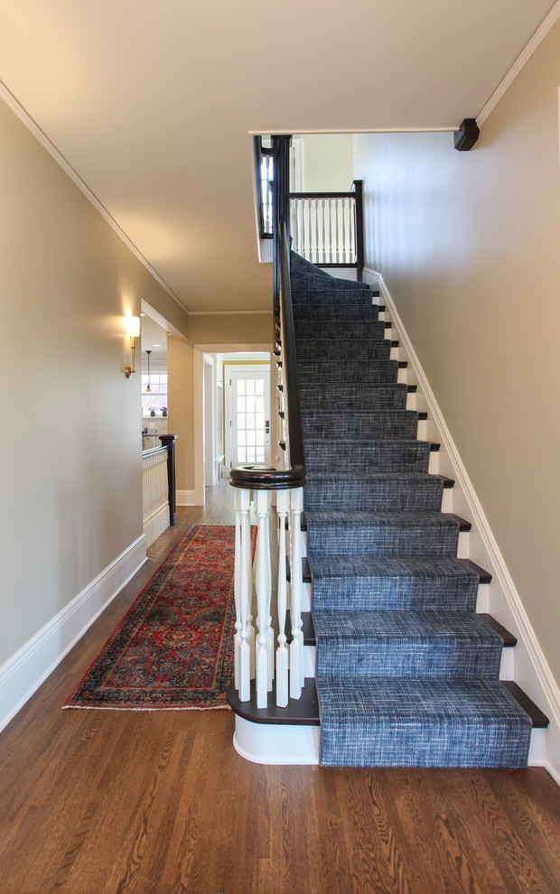 Aménagement d'un escalier peint courbe classique de taille moyenne avec des marches en moquette et un garde-corps en bois.