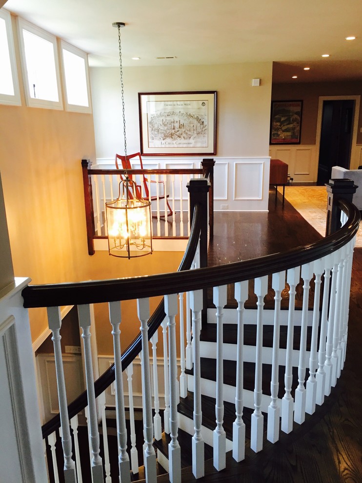 Пример оригинального дизайна: изогнутая лестница среднего размера в стиле неоклассика (современная классика) с деревянными ступенями, крашенными деревянными подступенками и деревянными перилами