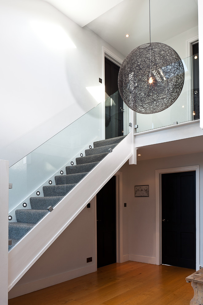 Design ideas for a contemporary carpeted straight staircase in London with carpeted risers.