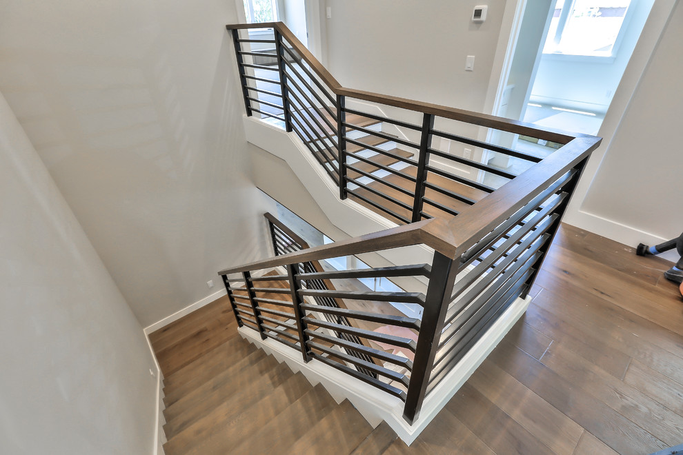Imagen de escalera en U moderna con escalones de madera, contrahuellas de madera pintada y barandilla de varios materiales