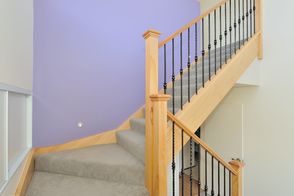 Foto de escalera en L contemporánea pequeña con escalones de madera, contrahuellas de madera y barandilla de metal