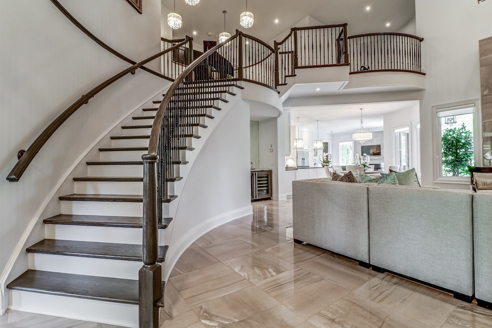Example of a transitional wooden curved wood railing staircase design in Toronto with painted risers