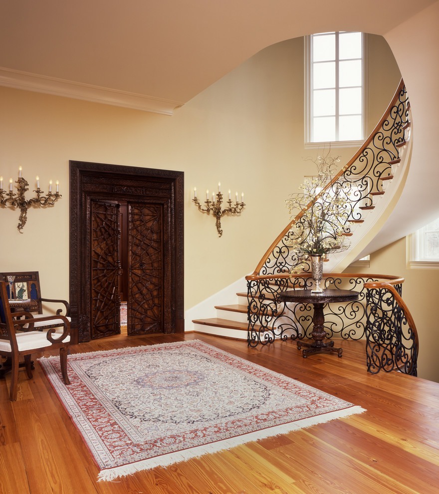 Idées déco pour un grand escalier peint courbe classique avec des marches en bois et un garde-corps en métal.