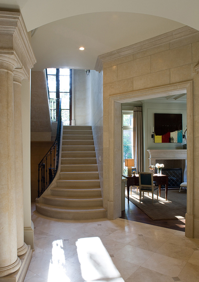 Imagen de escalera en U clásica pequeña con escalones de piedra caliza y contrahuellas de piedra caliza