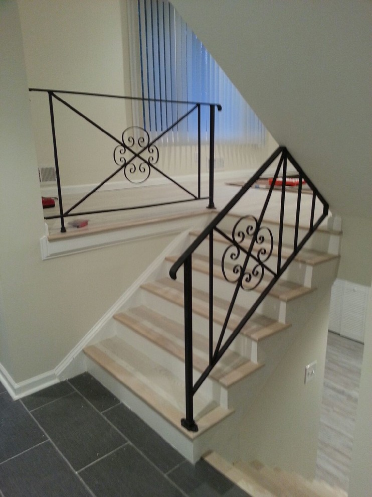 This is an example of a medium sized modern painted wood u-shaped metal railing staircase in DC Metro with painted wood risers.