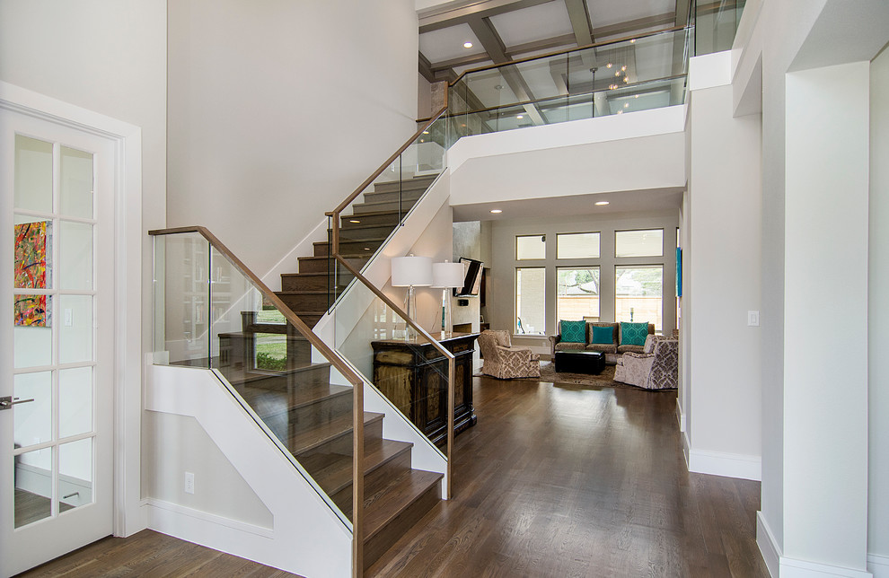 ダラスにあるトランジショナルスタイルのおしゃれな階段 (木の蹴込み板、ガラスフェンス) の写真