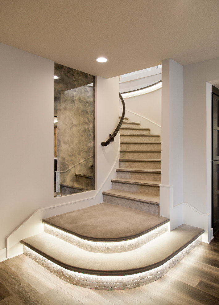 Стильный дизайн: большая изогнутая лестница в стиле модернизм с бетонными ступенями, подступенками из плитки и деревянными перилами - последний тренд