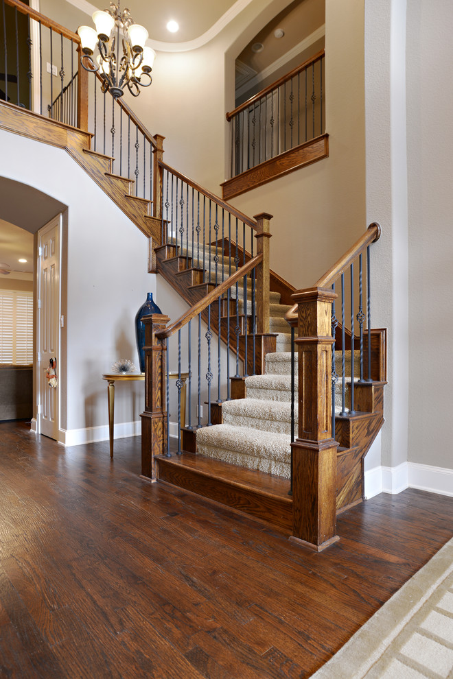 Imagen de escalera curva tradicional grande con escalones enmoquetados y contrahuellas de madera