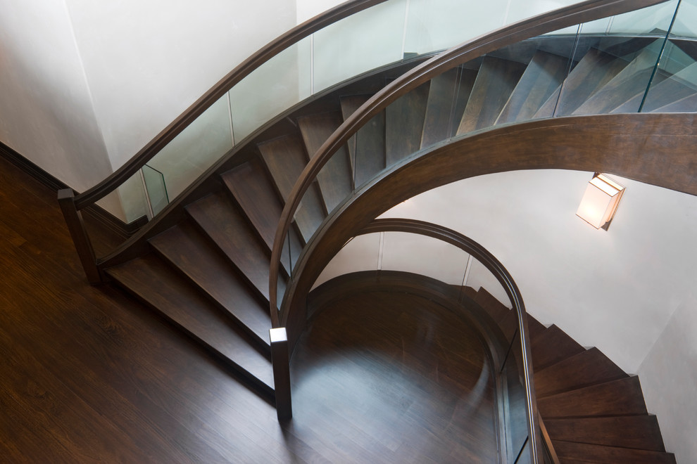 Réalisation d'un escalier courbe design avec des marches en bois.