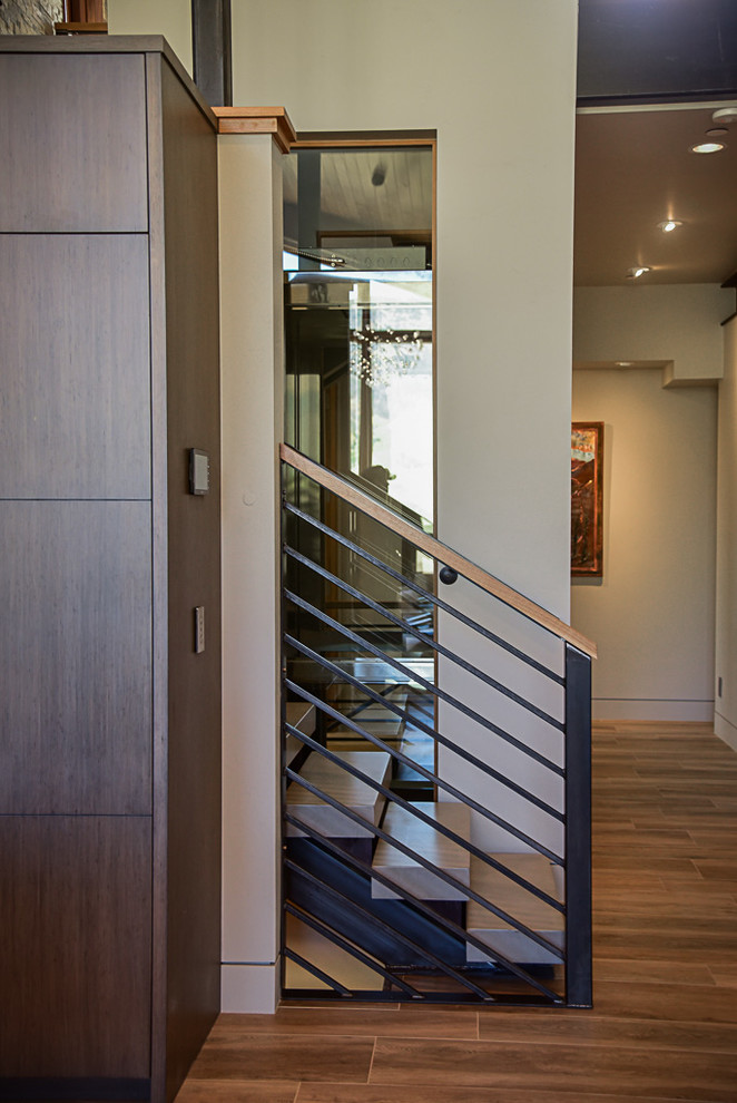 На фото: п-образная лестница среднего размера в стиле модернизм с металлическими перилами и ступенями из сланца без подступенок с