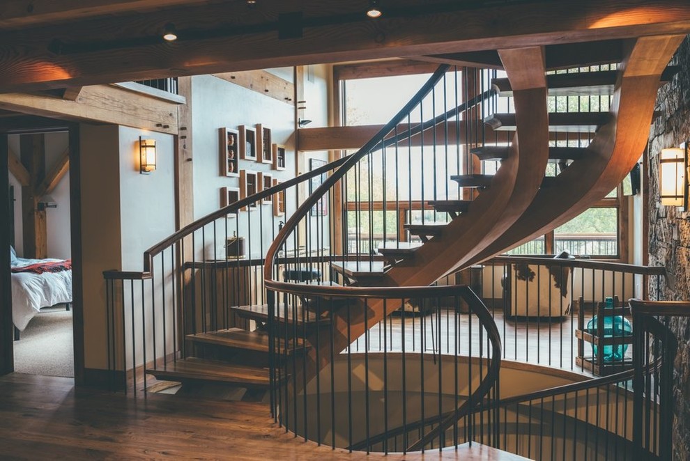 Large mountain style spiral wood railing staircase photo in Other