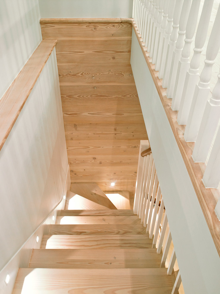 This is an example of a medium sized classic wood straight wood railing staircase in London with painted wood risers.