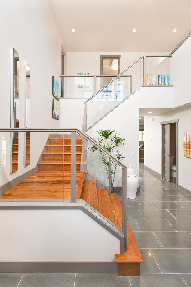 Стильный дизайн: деревянная лестница в современном стиле с деревянными ступенями и стеклянными перилами - последний тренд