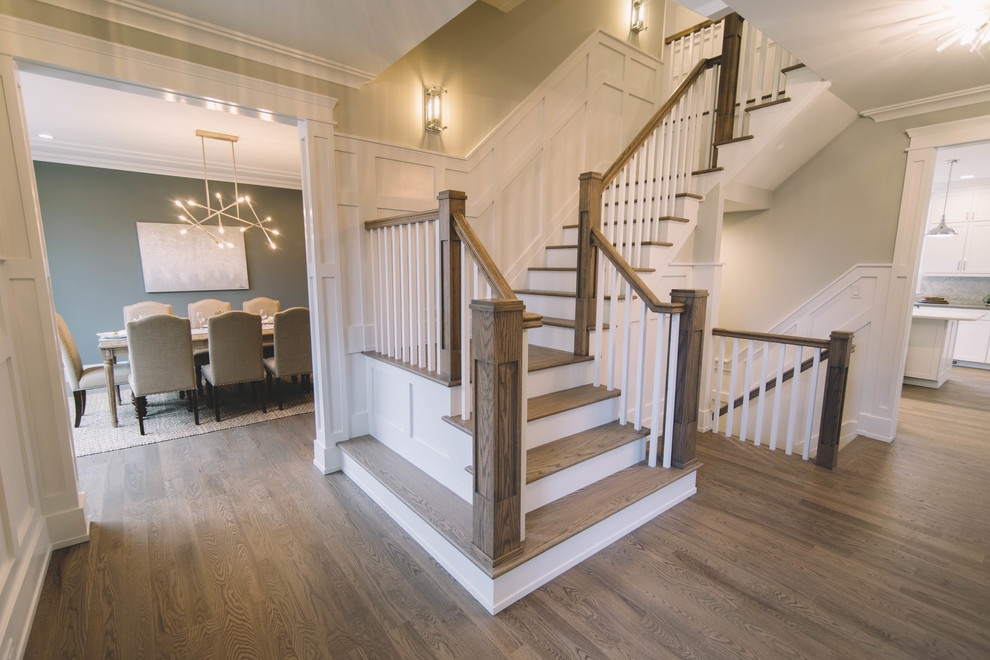 This is an example of a classic wood u-shaped wood railing staircase in New York with wood risers.